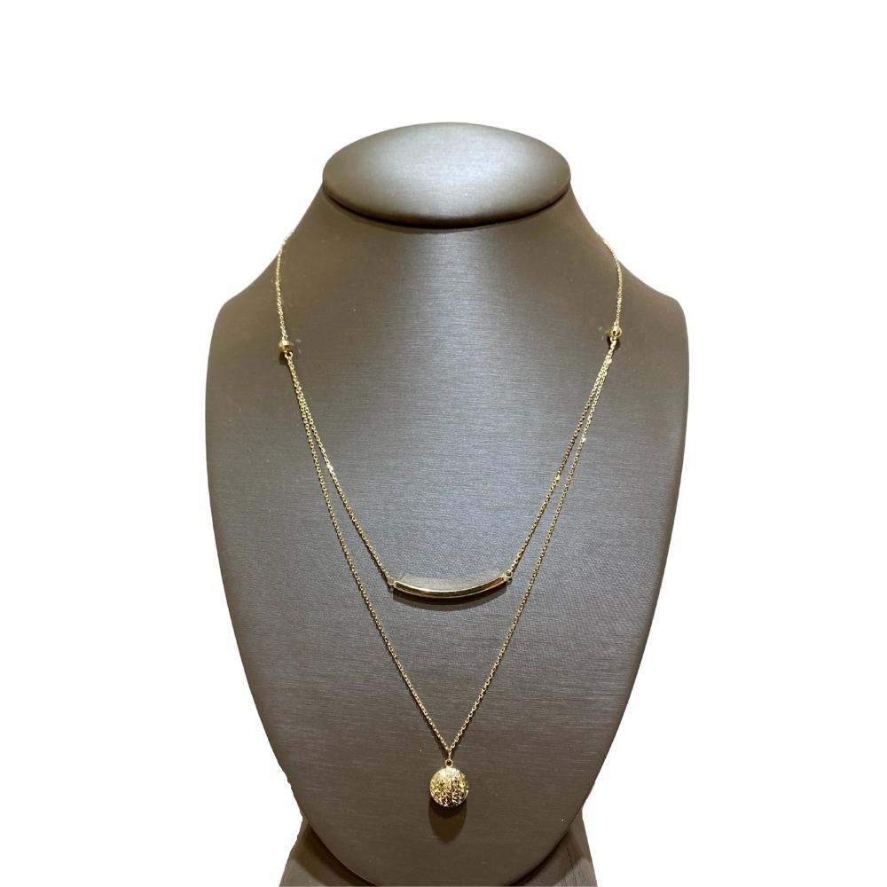 a necklace on a mannequin with a gold disc