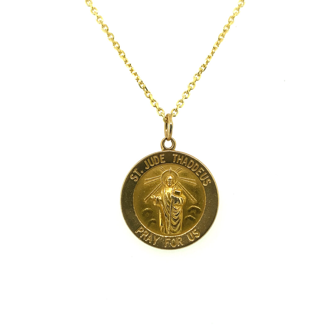 a gold necklace with a medal on it