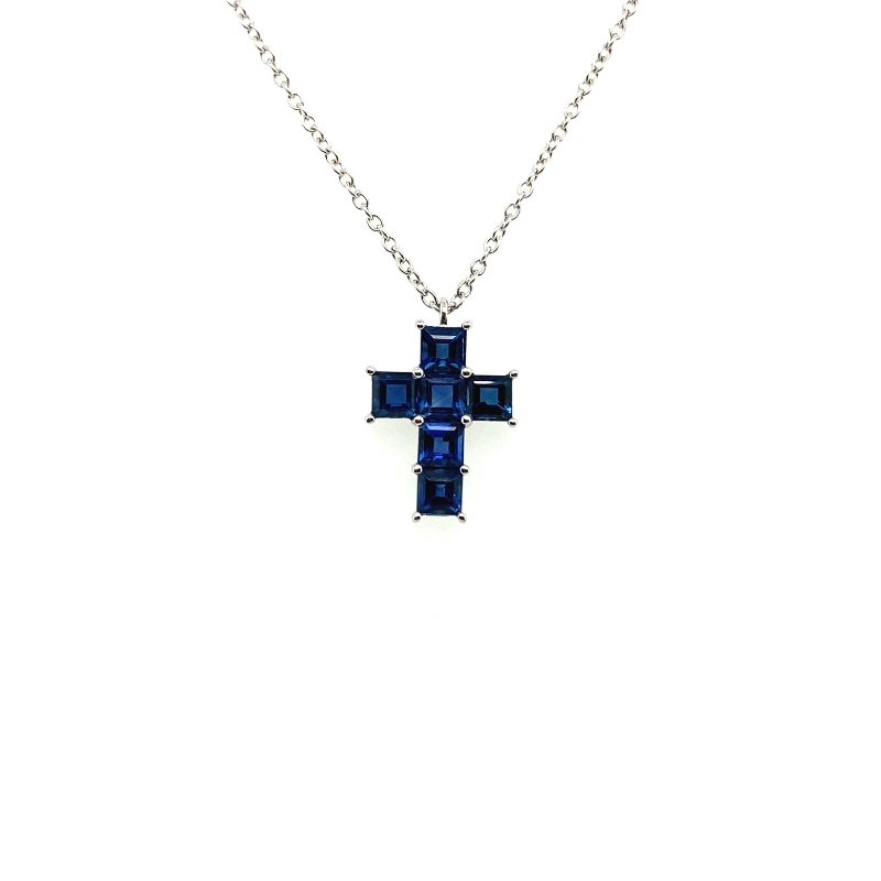 a blue cross necklace on a white background