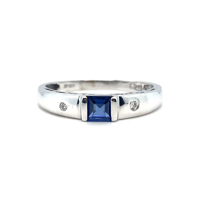 a white gold ring with a blue sapphire and diamonds