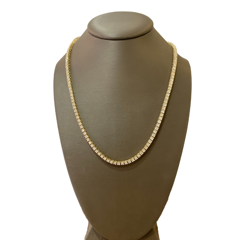 a gold necklace on a mannequin