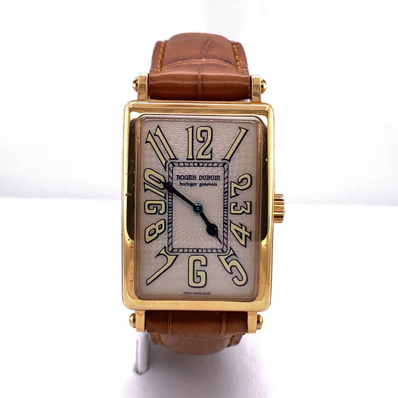 a square watch with brown leather straps on a white surface