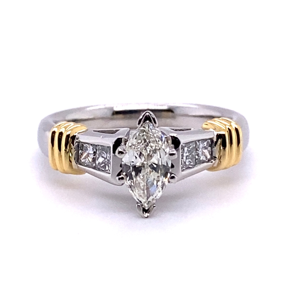 a white and yellow gold ring with a pear shaped diamond