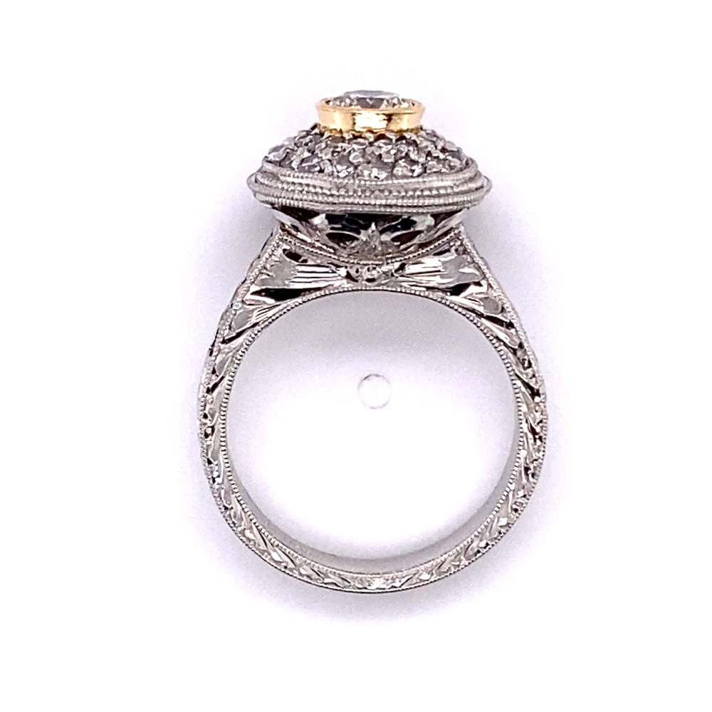an antique style engagement ring with two tone gold accents