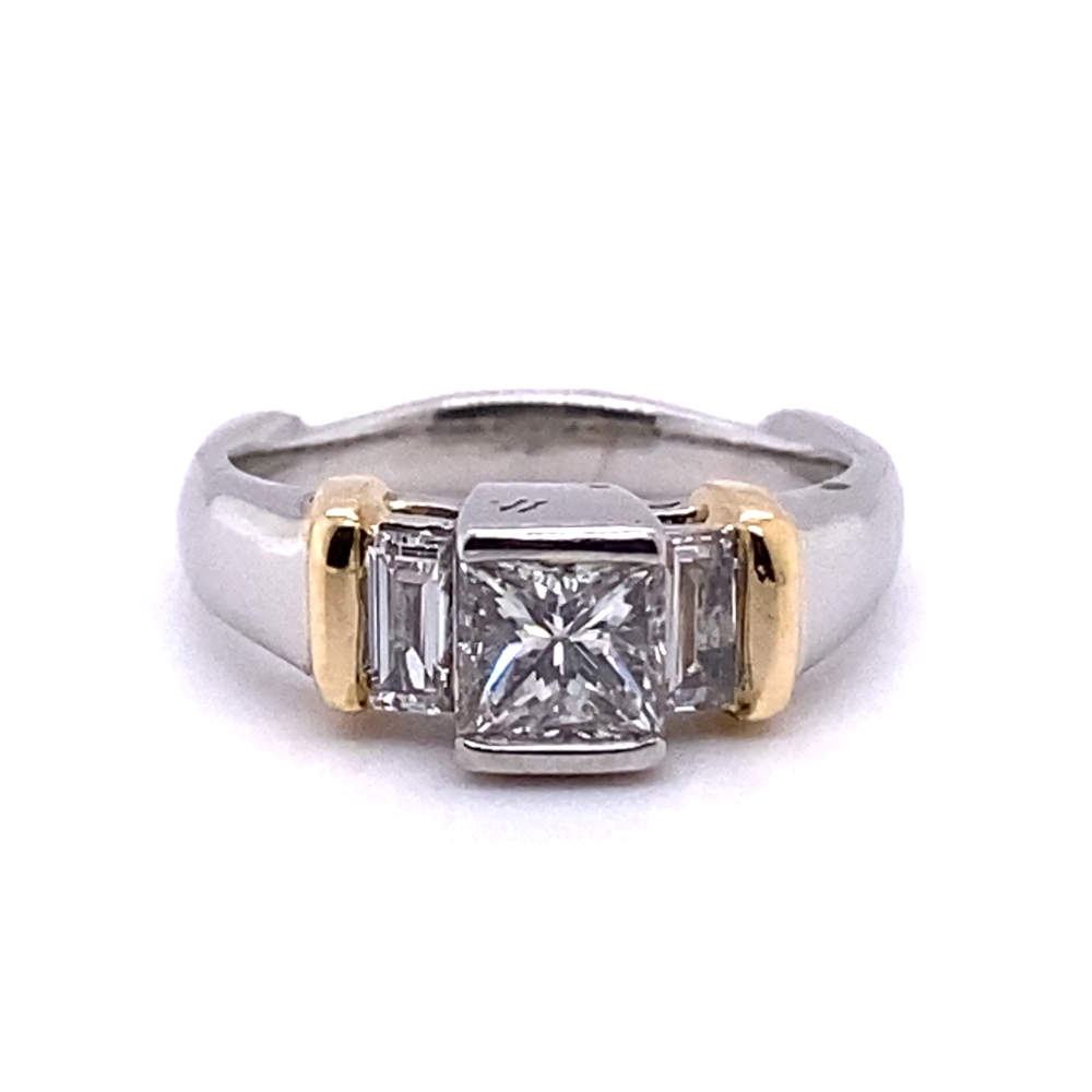 a three stone diamond ring with two tone gold accents