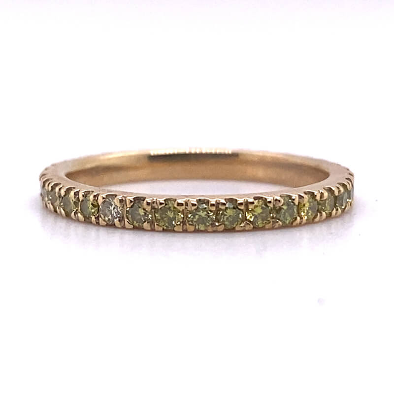 a yellow gold band with green diamonds