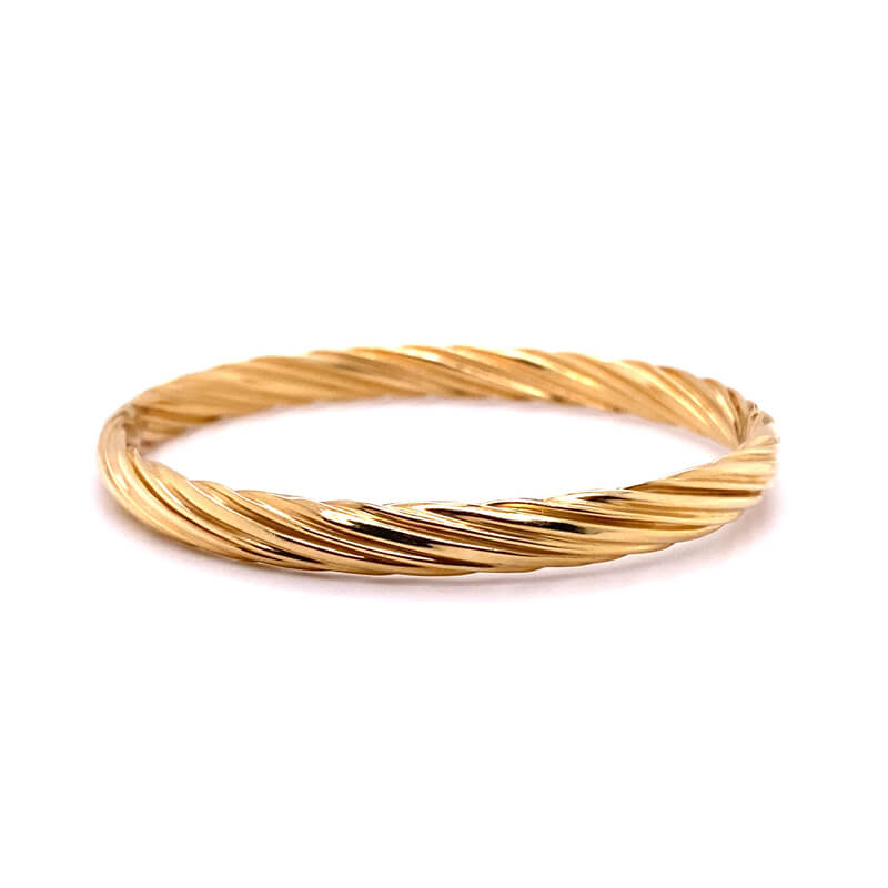 a yellow gold twisted ring on a white background