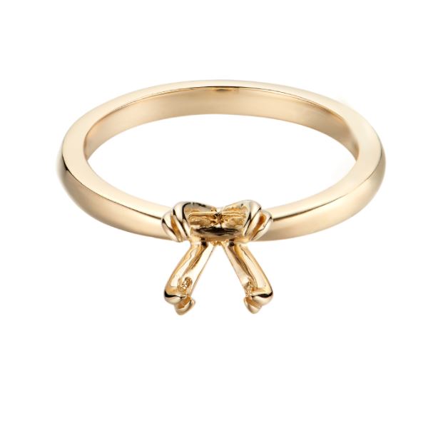 a gold ring with a bow on it