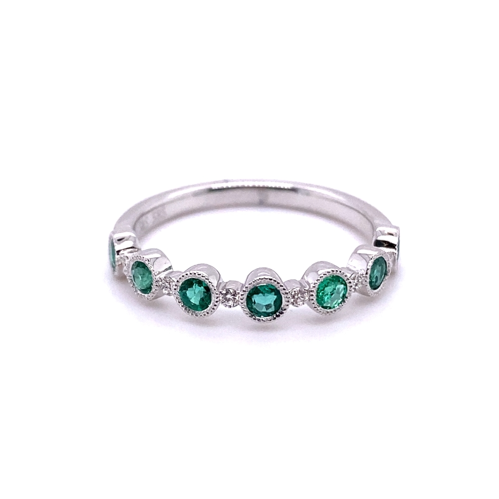 a white gold ring with green stones