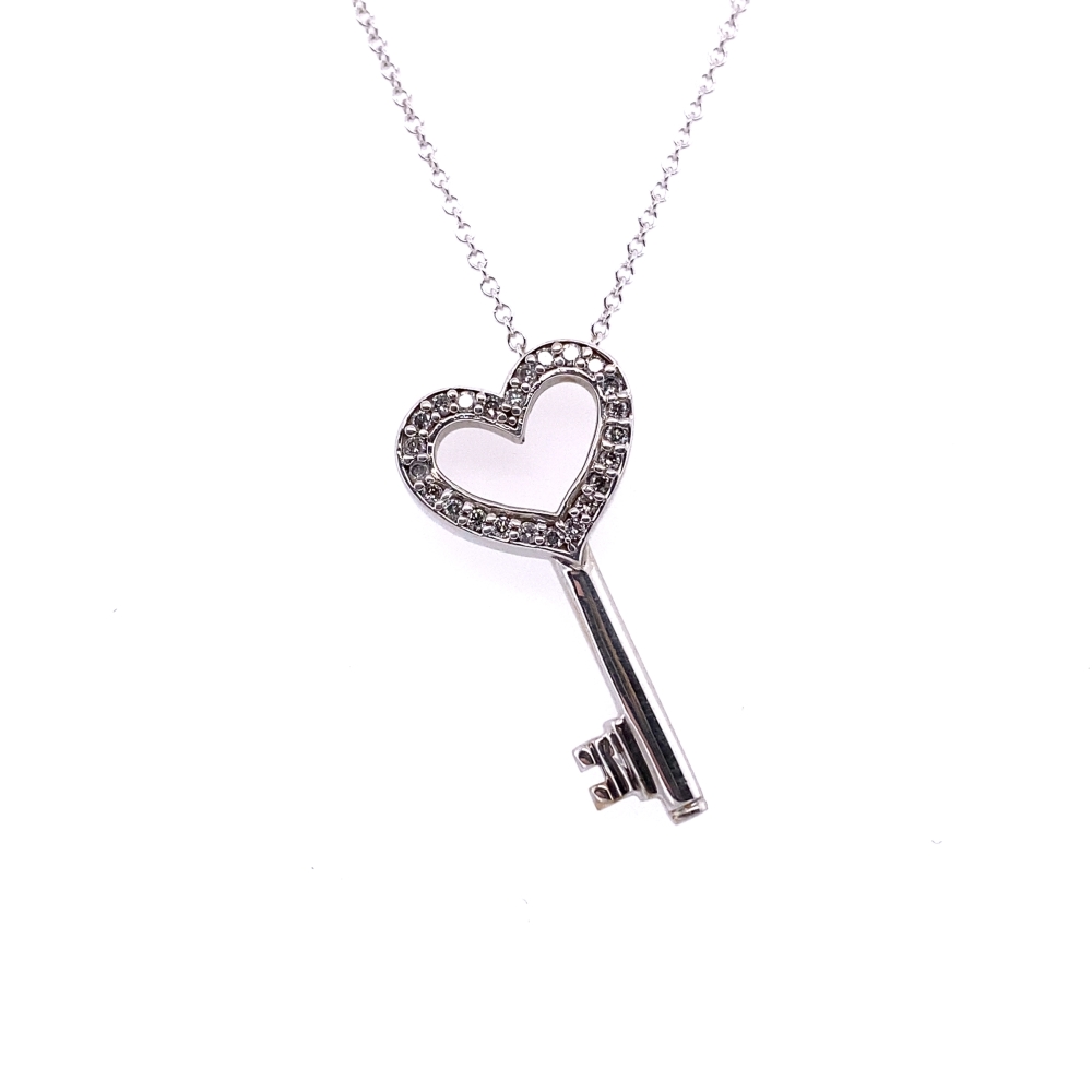 a heart shaped key is hanging from a chain