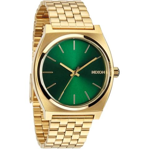 a gold watch with green dials on a white background