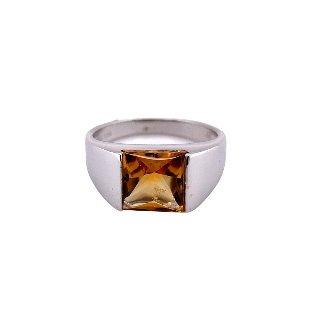 a silver ring with an orange stone in the center