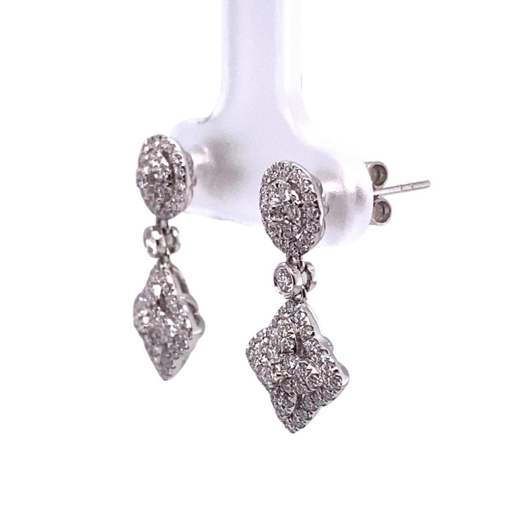 a pair of diamond earrings hanging from a hook