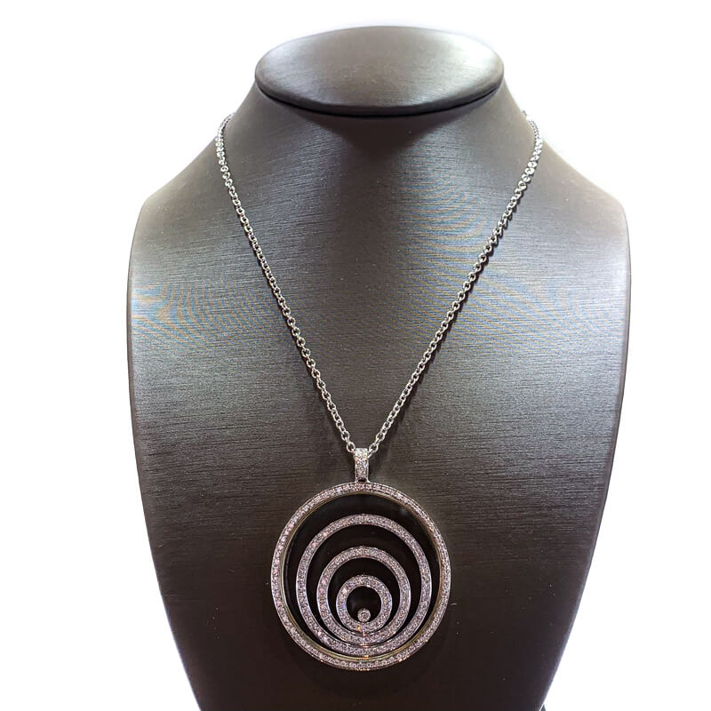 a necklace on a mannequin with a circular pendant