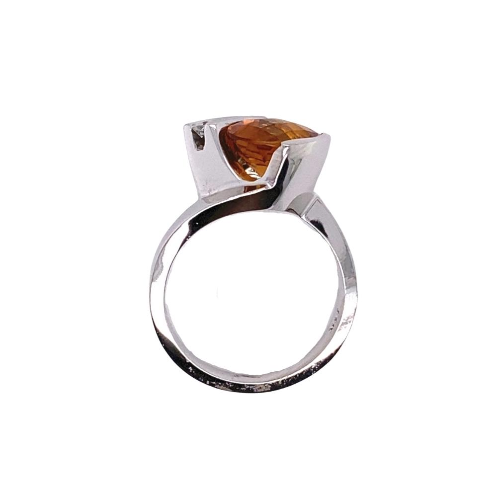a silver ring with an orange stone in it