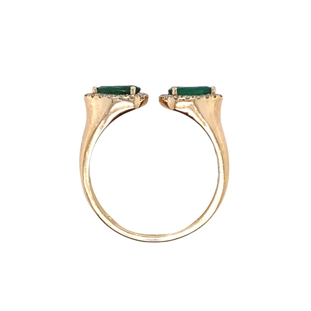 a gold ring with two green stones on it