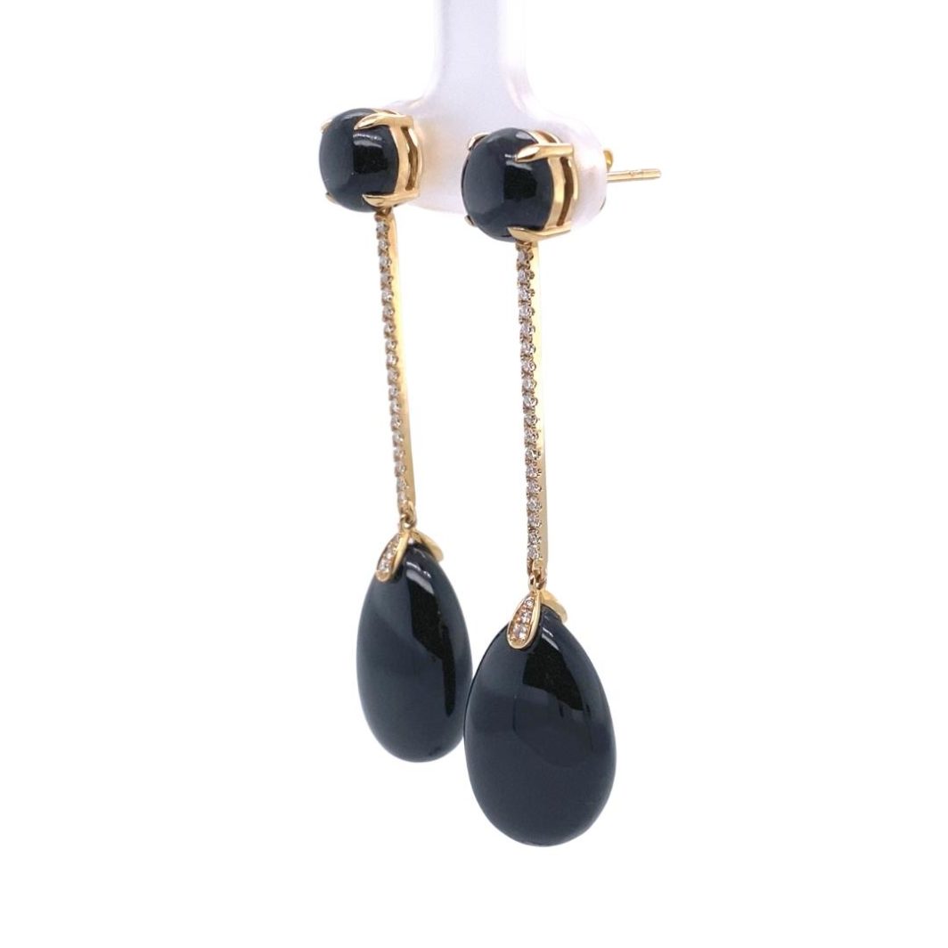 a pair of black and gold earrings