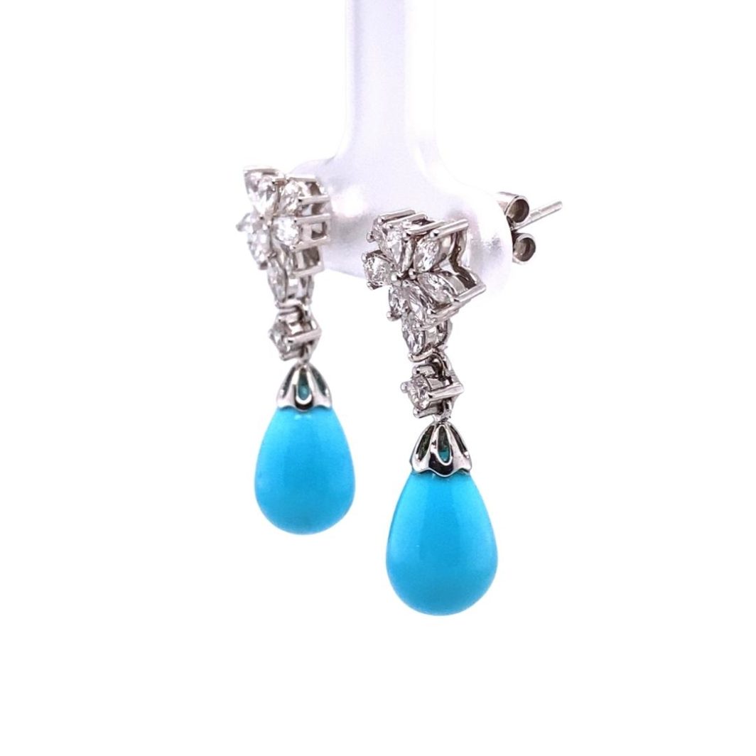 a pair of blue earrings hanging from a hook