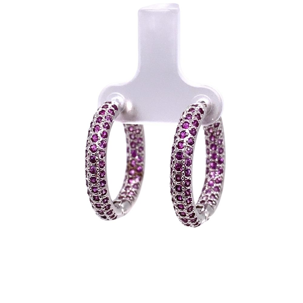 a pair of hoop earrings with purple stones