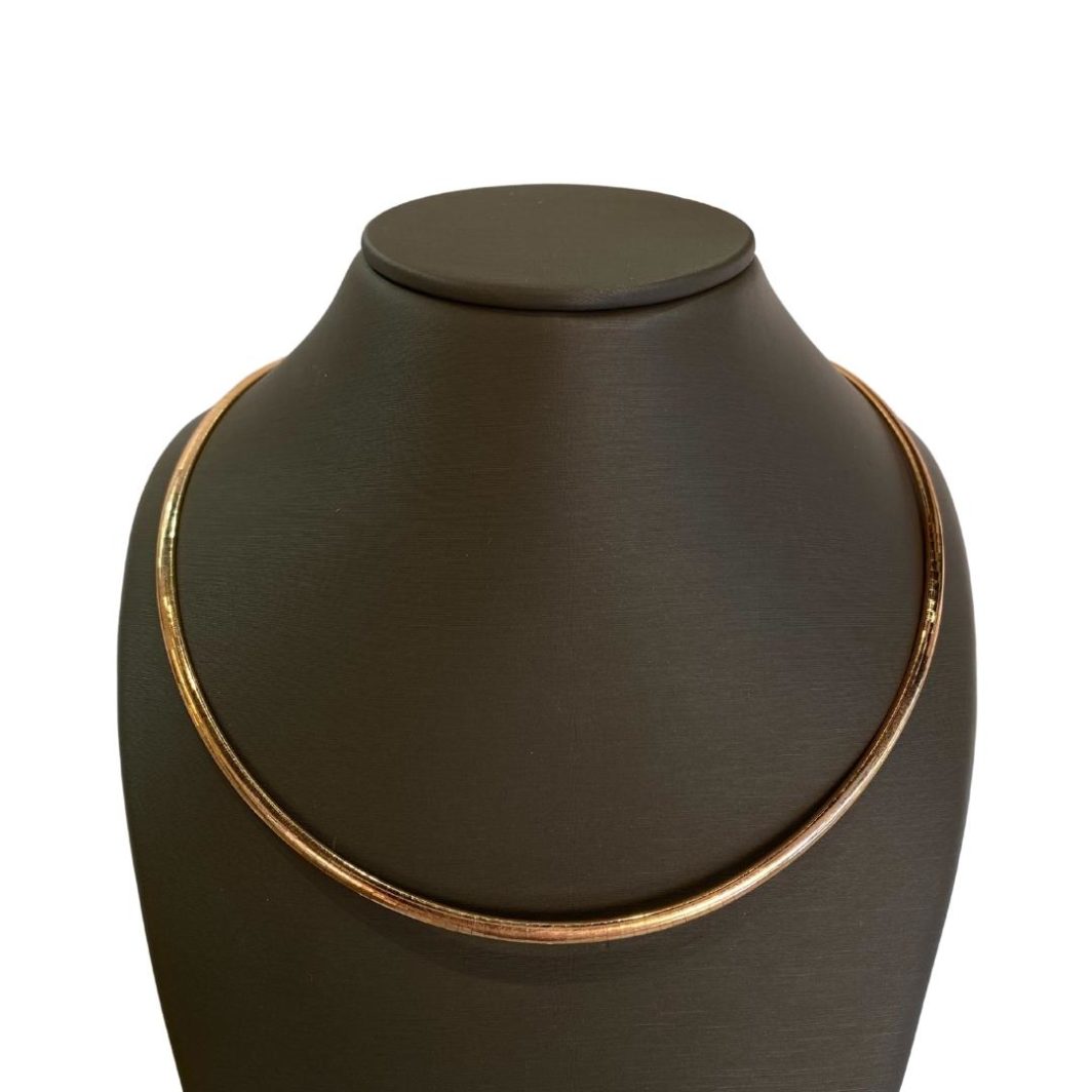 a black vase with a gold necklace on it