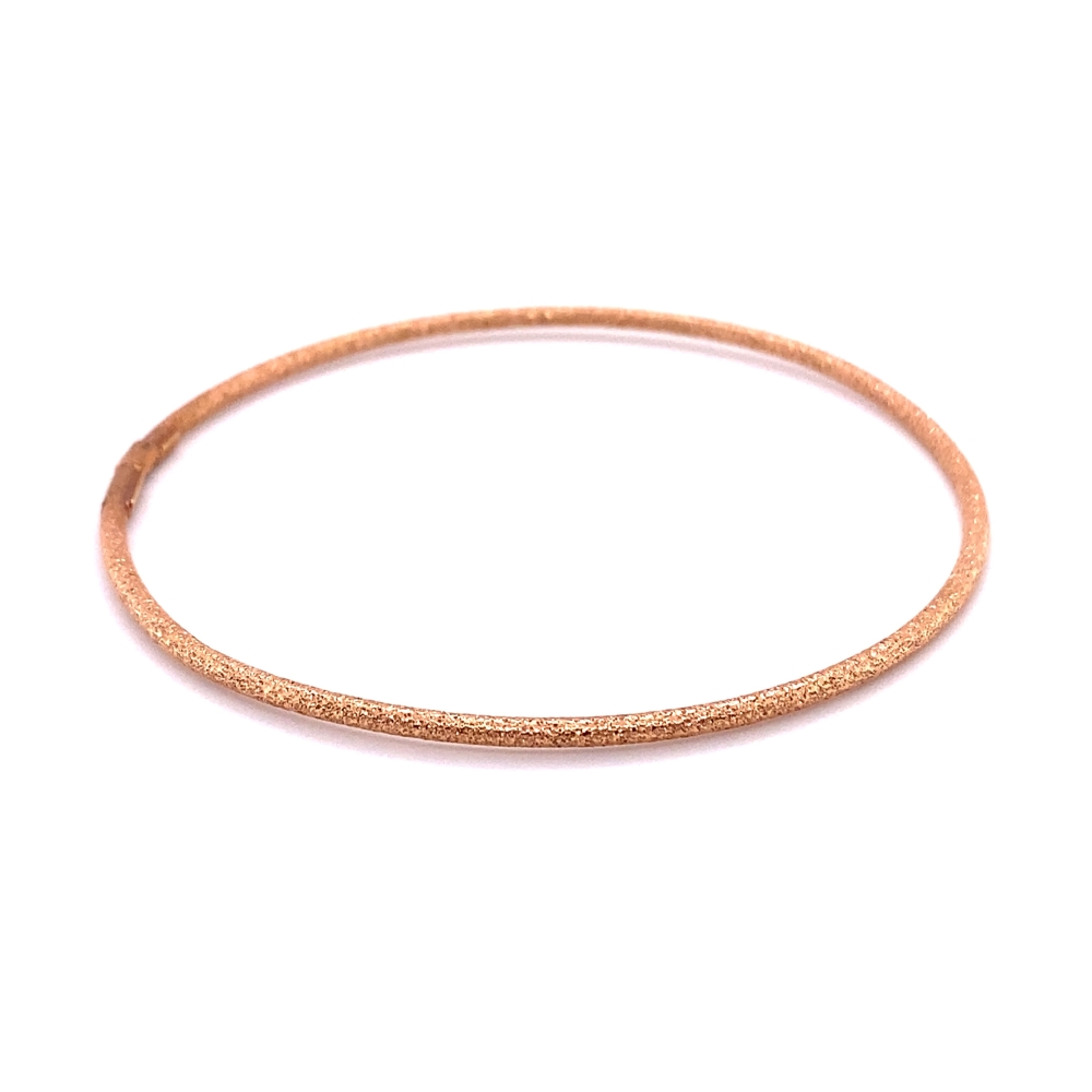 a thin gold bang bracelet on a white background