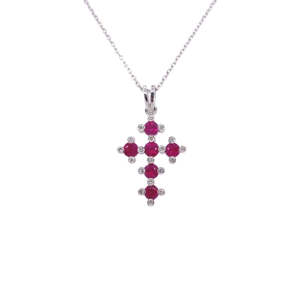 a cross pendant with red stones on a chain