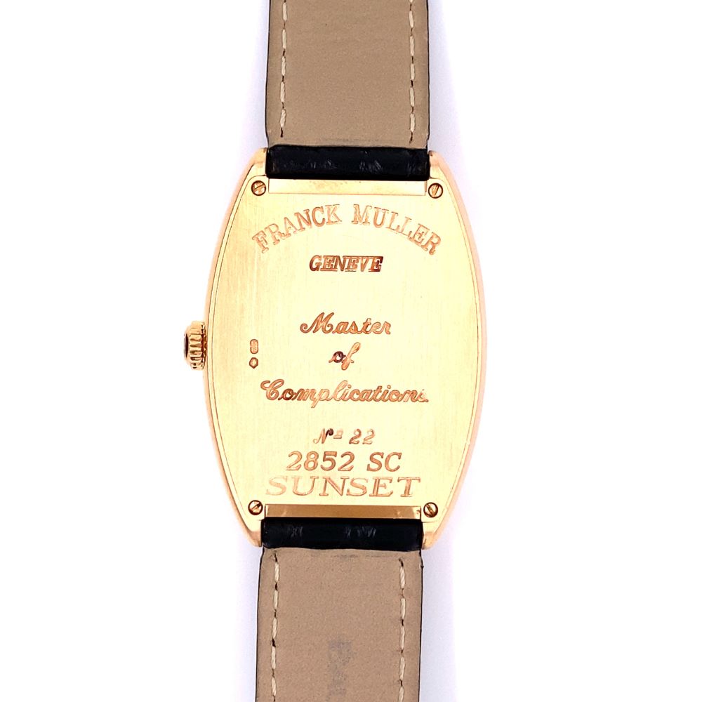 a gold watch with brown leather straps on a white background