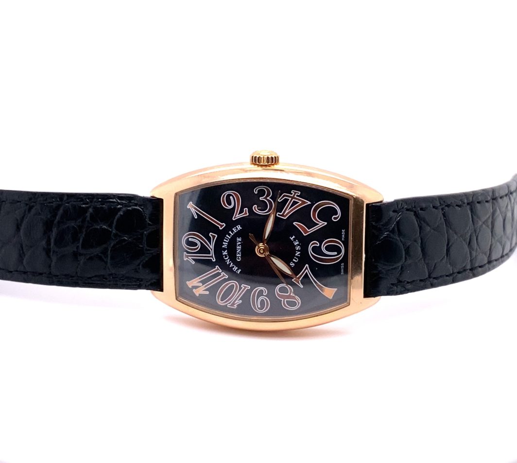 a black and gold wrist watch with roman numerals