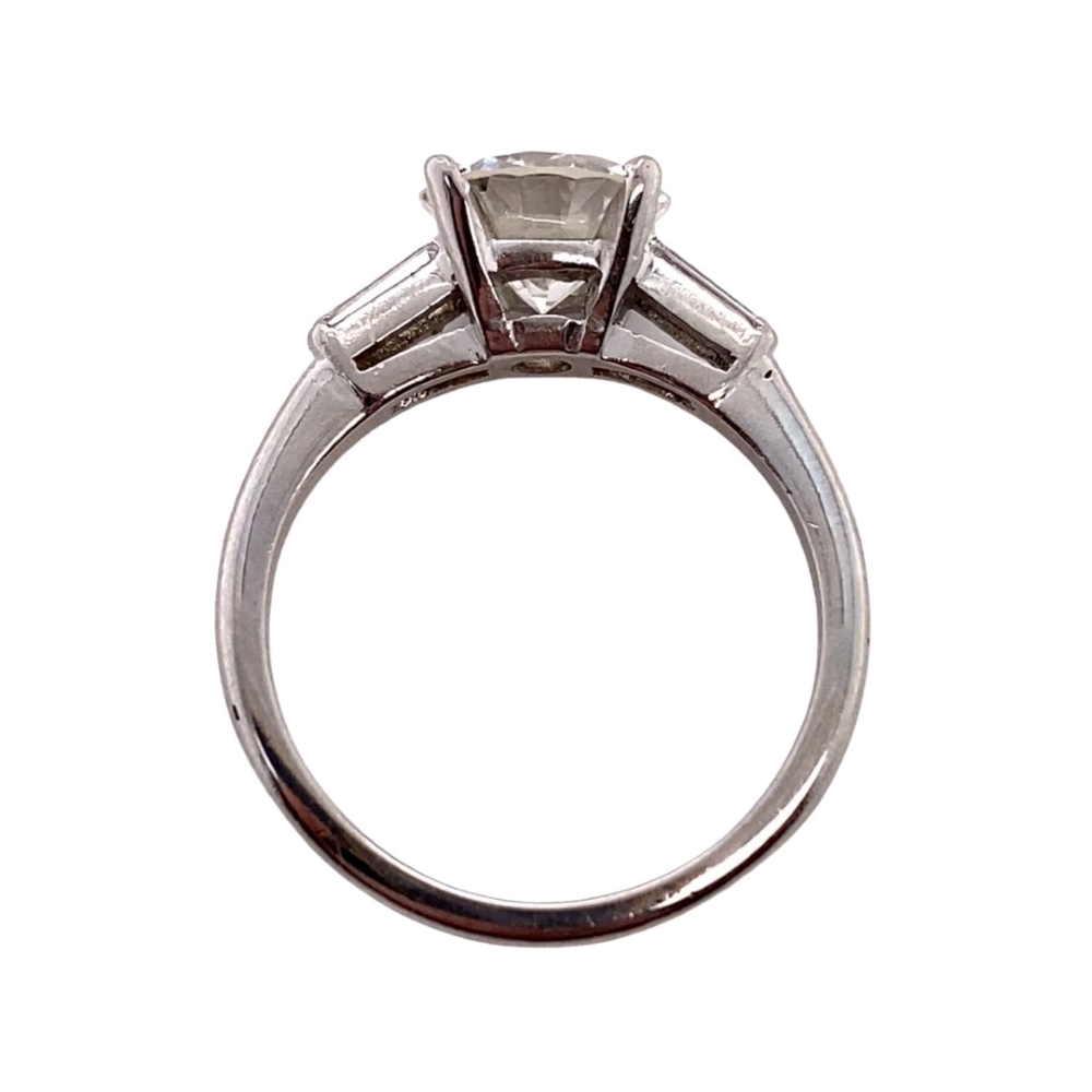 an engagement ring with three baguetts on the side