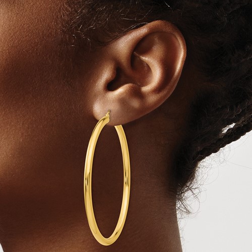 a close up of a person wearing large gold hoop earrings
