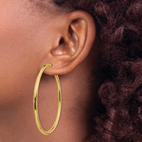 a close up of a woman wearing large gold hoop earrings