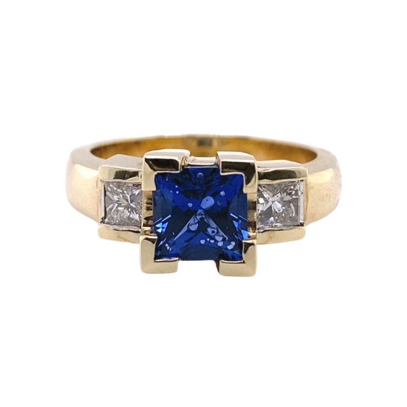 a ring with a blue stone and two diamonds