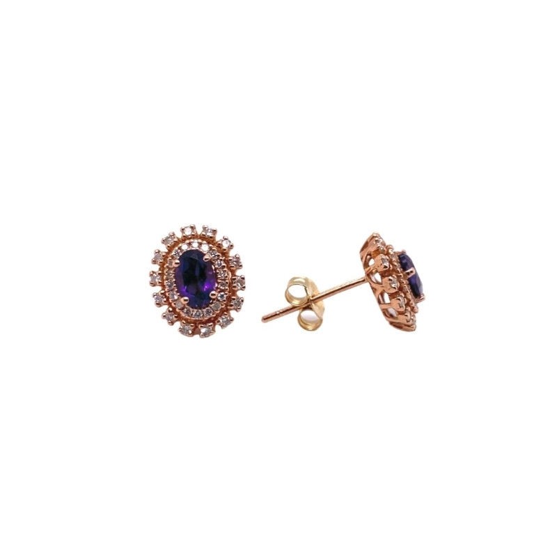 a pair of earrings with a purple stone in the center