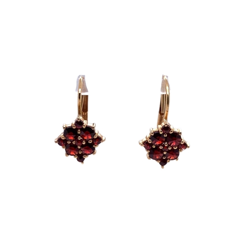 a pair of earrings with red stones on them