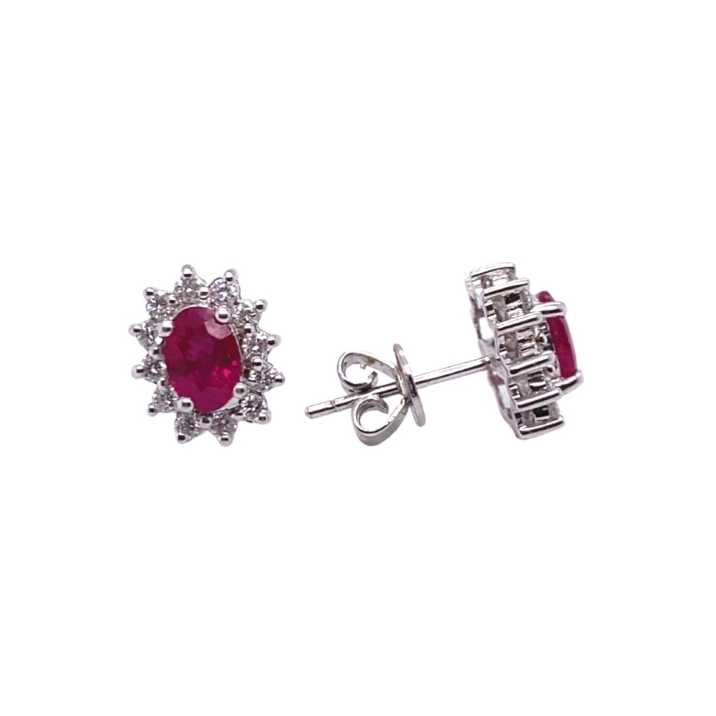 a pair of earrings with a red stone