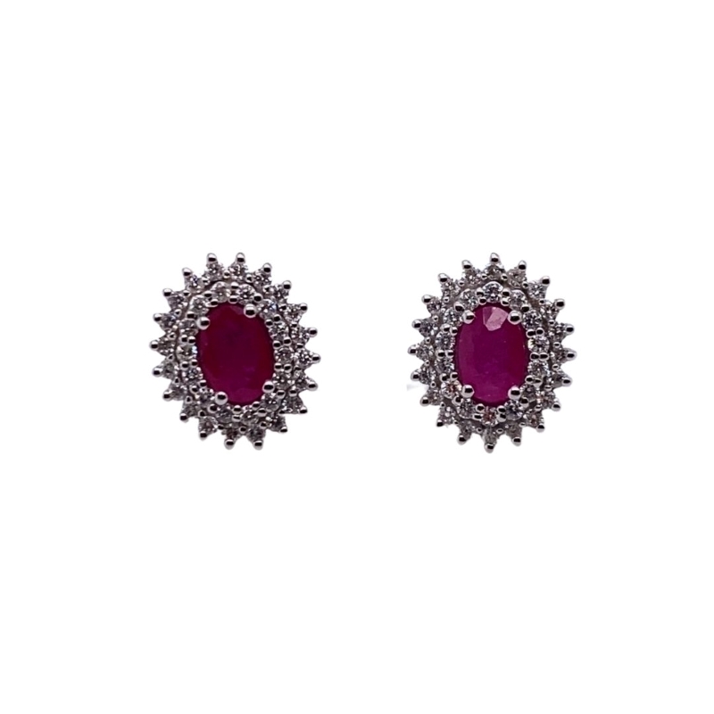 a pair of earrings with red stones
