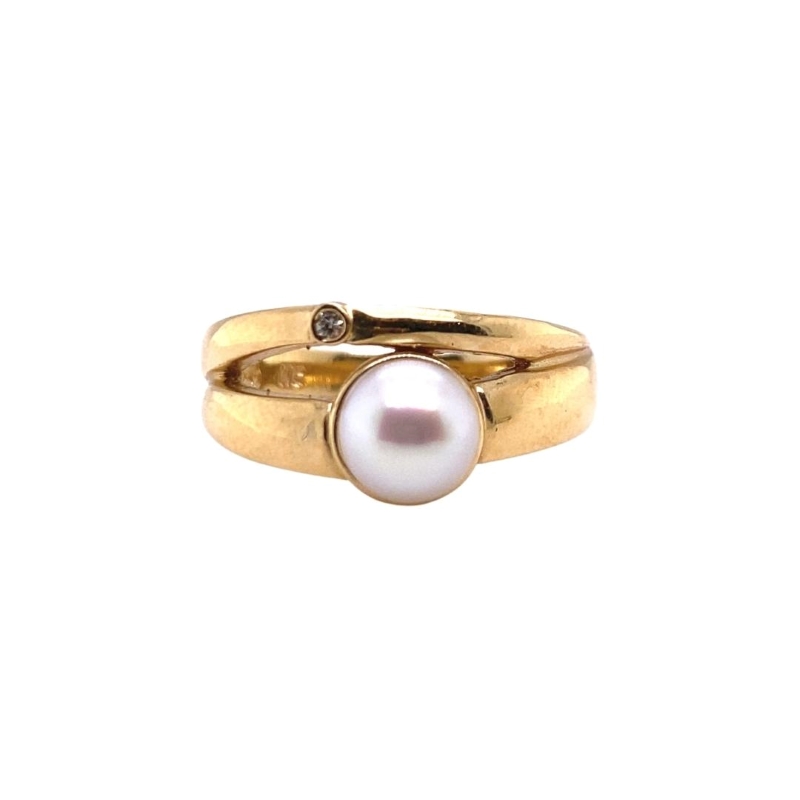 a gold ring with a white pearl on it