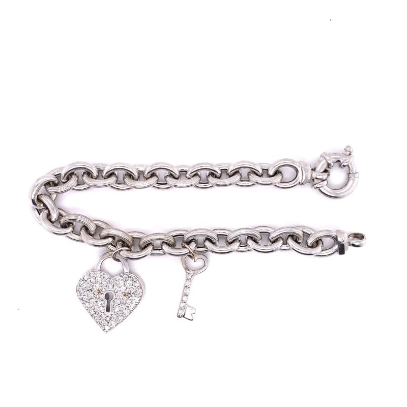 a silver bracelet with a heart and key