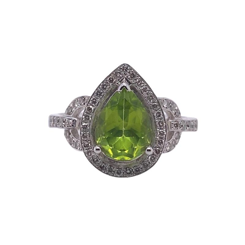 a ring with a pear shaped green stone surrounded by diamonds
