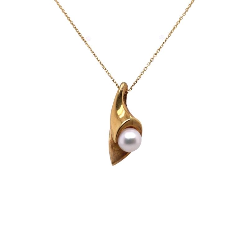 a gold necklace with a white pearl hanging from it