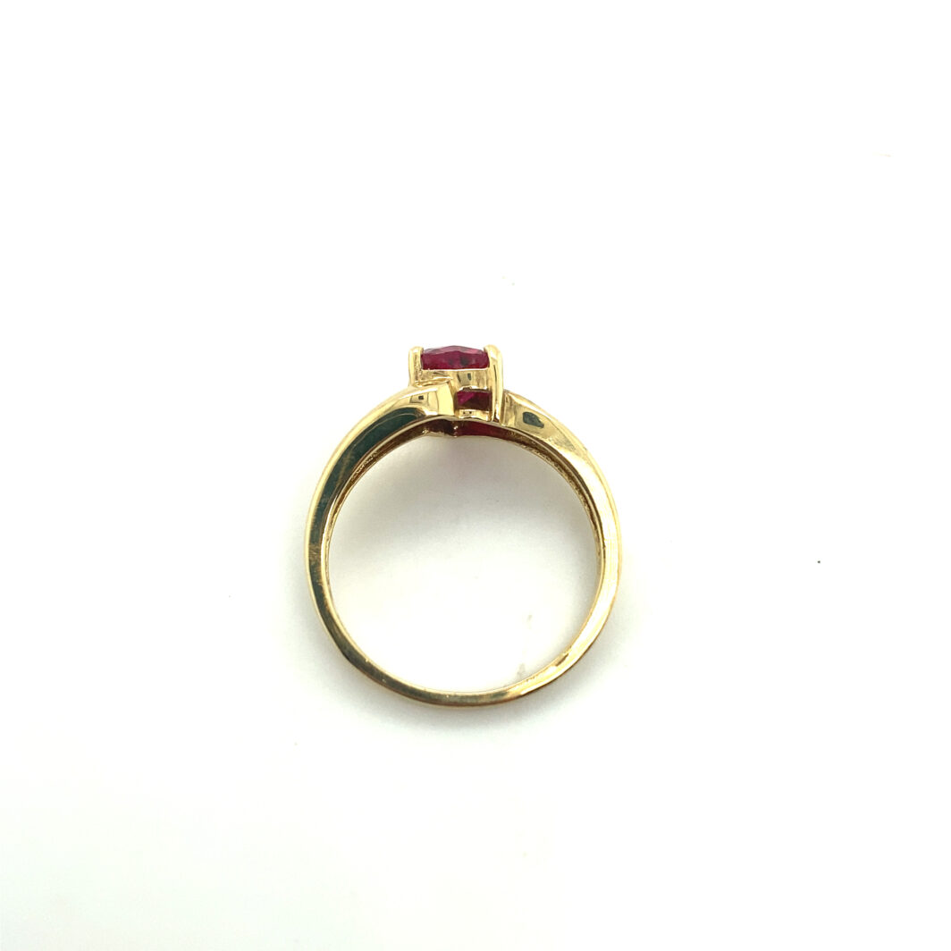 a gold ring with a red stone on it