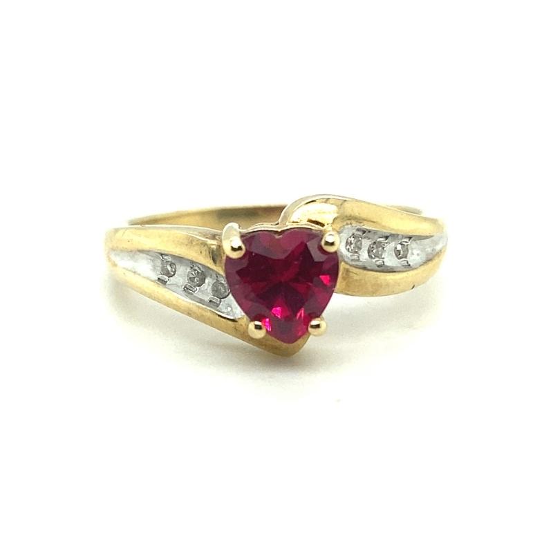 a ring with a heart shaped red stone and two white diamonds