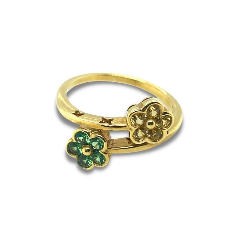 a gold ring with two clovers on it