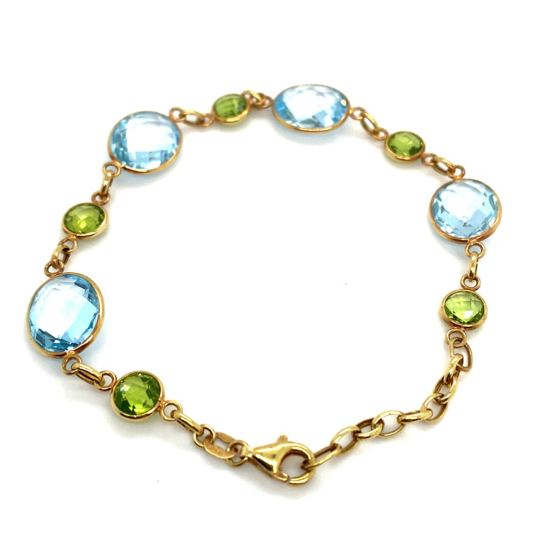 a gold bracelet with blue, green and yellow stones