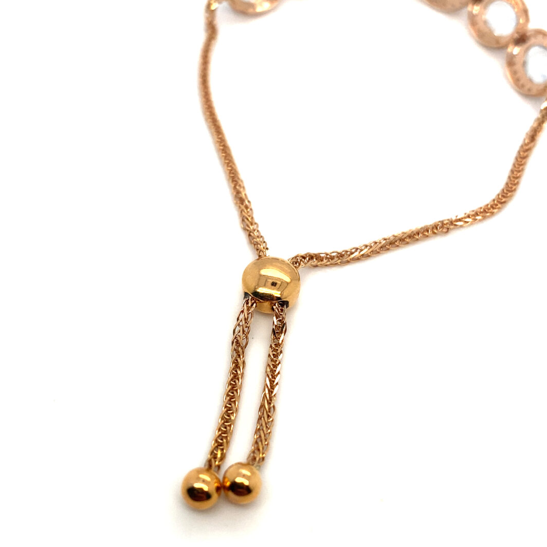 a gold necklace with two balls hanging from it