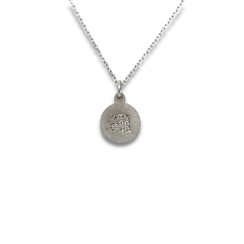 a silver necklace with a small initial on it