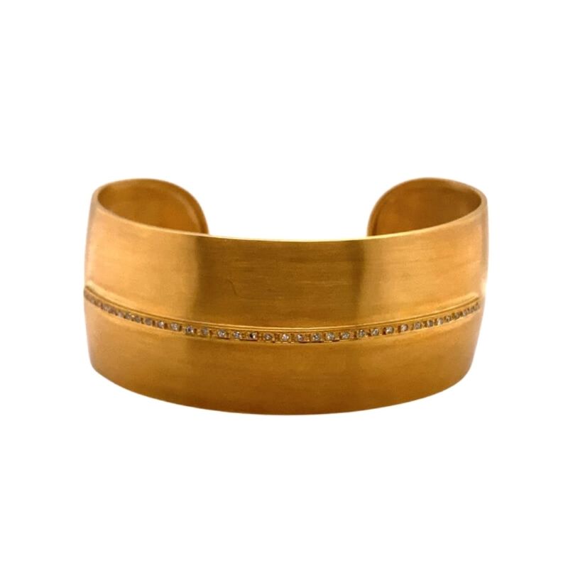 a gold cuff bracelet with two rows of beads