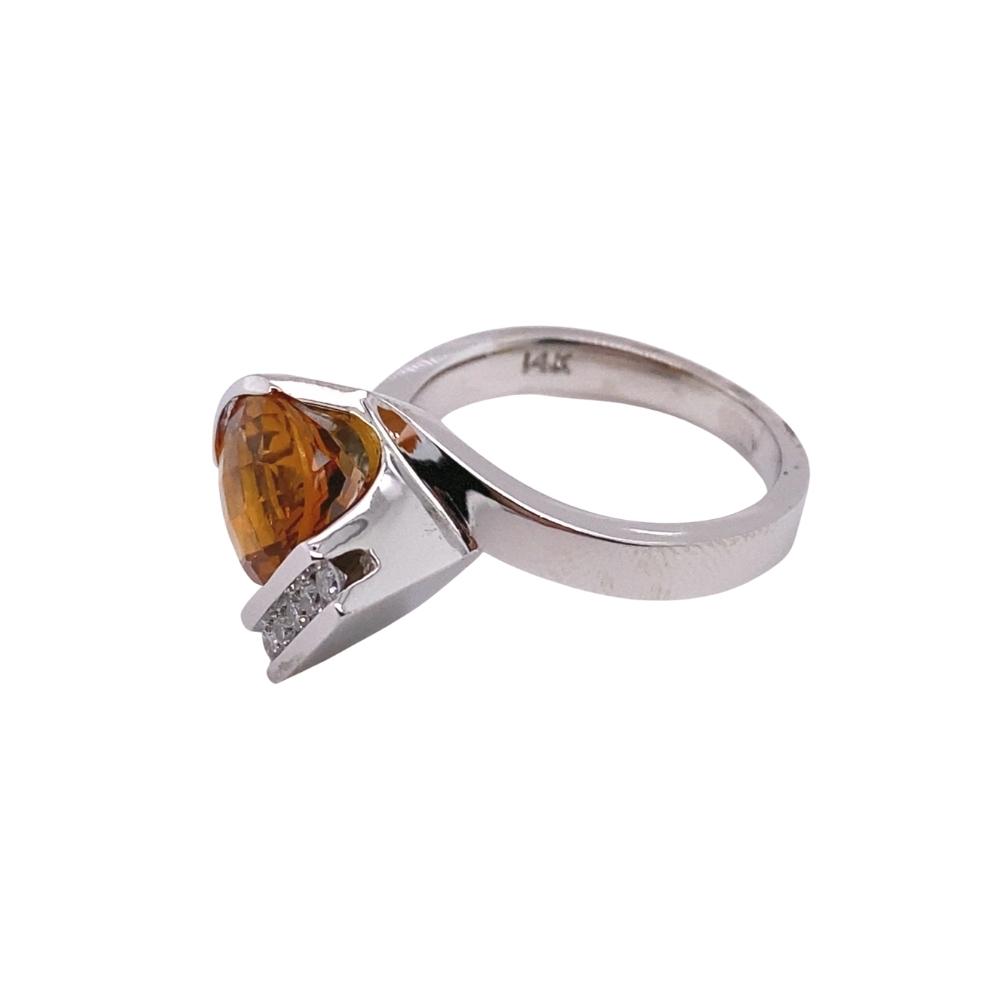 a silver ring with an orange stone in the middle
