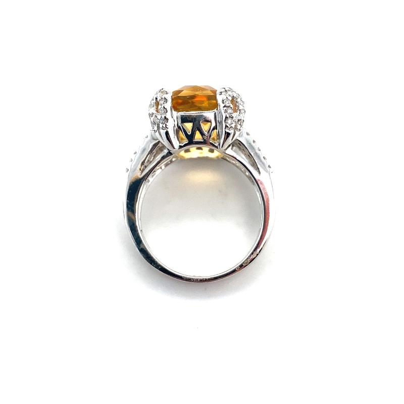 a ring with an orange stone and diamonds