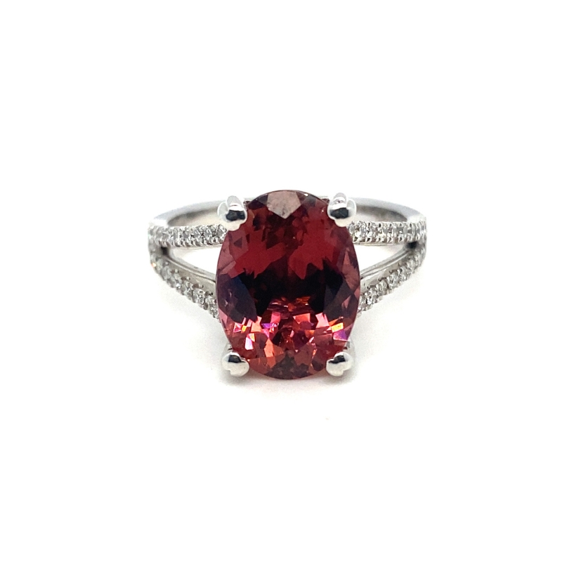 a ring with a large red stone surrounded by diamonds